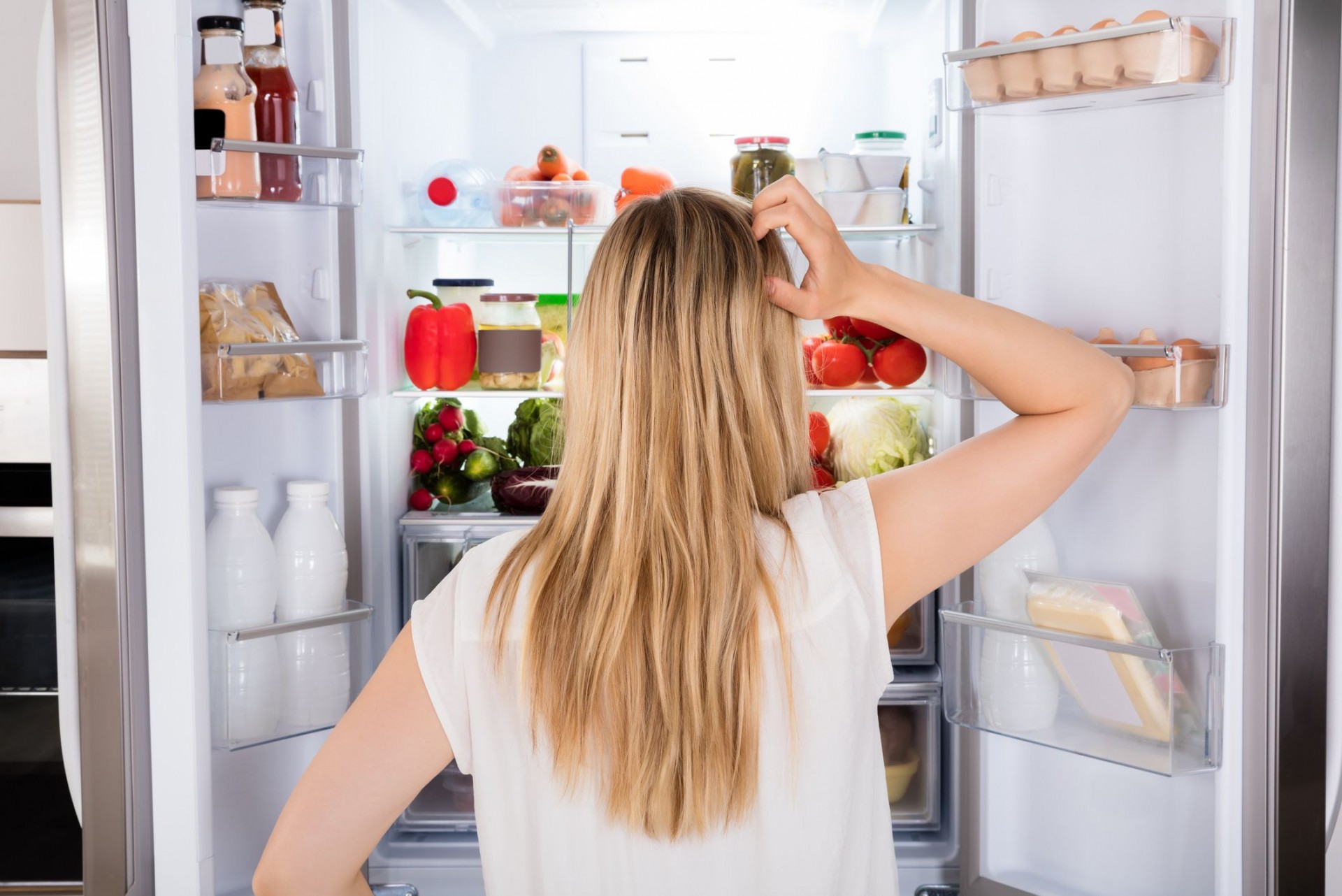 rear-view-of-woman-looking-in-fridge-royalty-free-image-859444676-1559217243